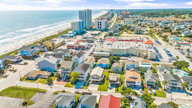 birds eye view of property featuring a water view and a beach view