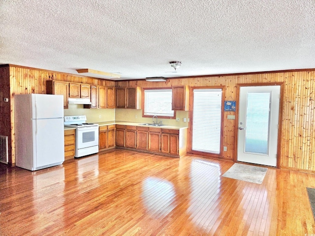 209 25th Ave N, North Myrtle Beach, SC 29582 - kitchen with white appliances, a sink, under cabinet range hood, light wood finished floors, and light countertops