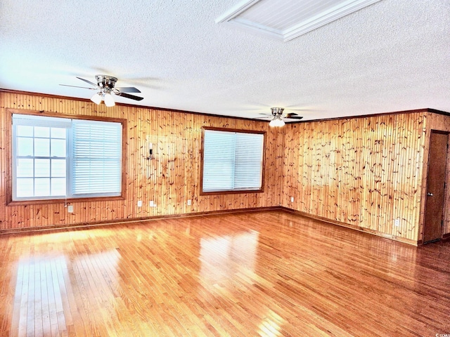 209 25th Ave N, North Myrtle Beach, SC 29582 - unfurnished room with wood finished floors, ceiling fan, a textured ceiling, baseboards, and wooden walls