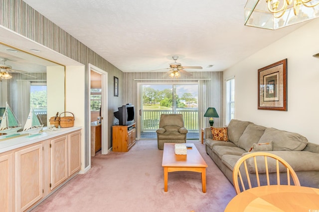 living area featuring a ceiling fan, a wealth of natural light, and light colored carpet