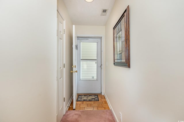 entryway with carpet, visible vents, and baseboards
