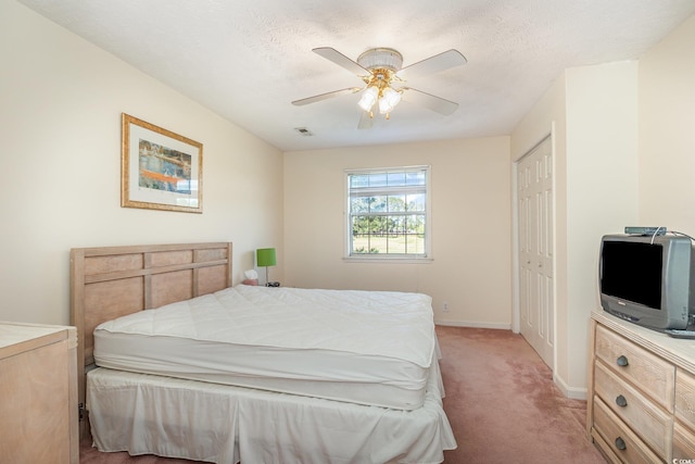 bedroom with a ceiling fan, a textured ceiling, baseboards, visible vents, and light colored carpet