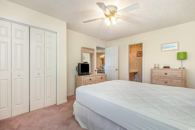 bedroom featuring a ceiling fan, light carpet, and a closet
