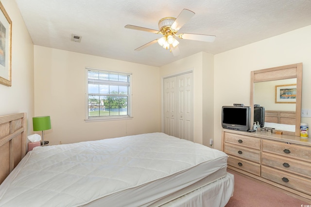 bedroom with carpet floors, a closet, a ceiling fan, and visible vents