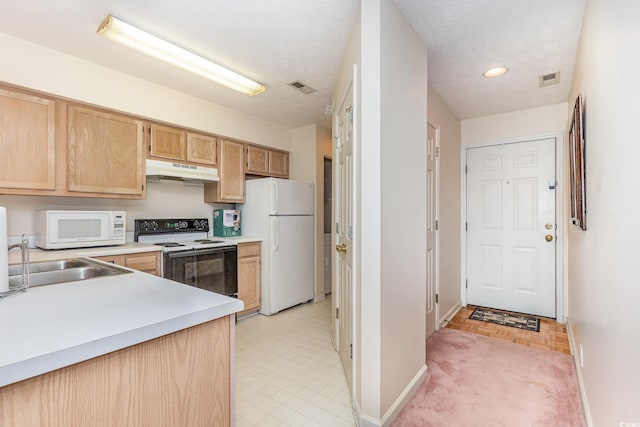 kitchen with light brown cabinetry, under cabinet range hood, baseboards, white appliances, and light countertops