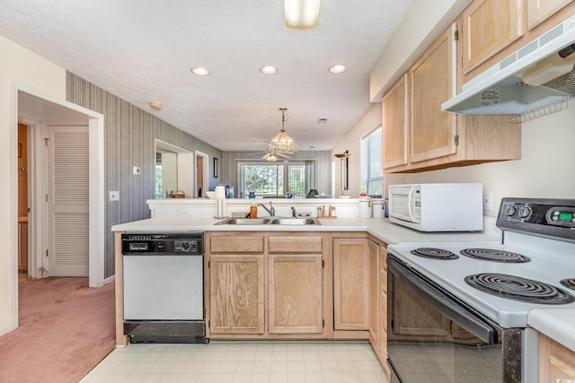 kitchen featuring a sink, a peninsula, white appliances, under cabinet range hood, and light brown cabinetry