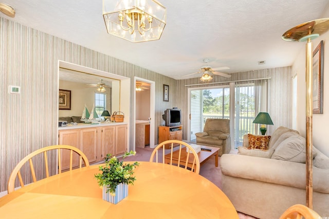 dining room with a ceiling fan, light carpet, visible vents, and wallpapered walls