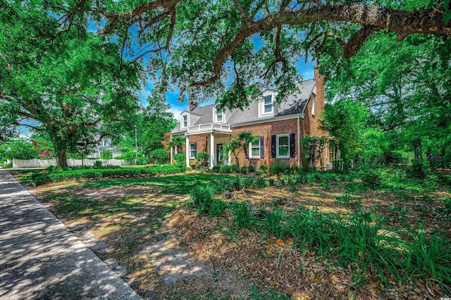 402 E Broad St, Hemingway, SC 29554 - cape cod-style house featuring brick siding, a balcony, and a chimney