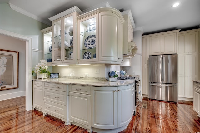 402 E Broad St, Hemingway, SC 29554 - kitchen with stainless steel appliances, ornamental molding, wood finished floors, white cabinetry, and recessed lighting