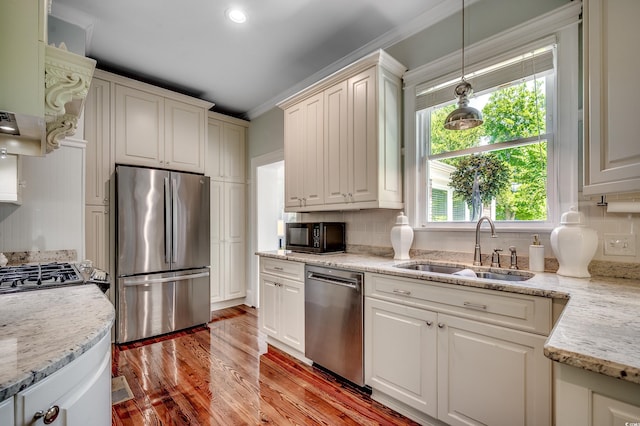 402 E Broad St, Hemingway, SC 29554 - kitchen with appliances with stainless steel finishes, a sink, light wood finished floors, backsplash, and pendant lighting