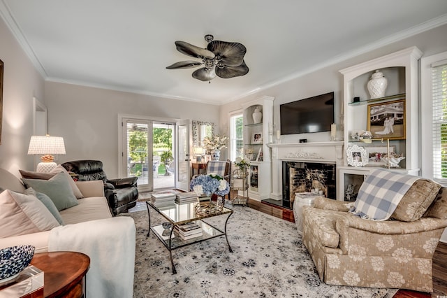 402 E Broad St, Hemingway, SC 29554 - living area featuring wood finished floors, crown molding, a ceiling fan, plenty of natural light, and a fireplace with raised hearth