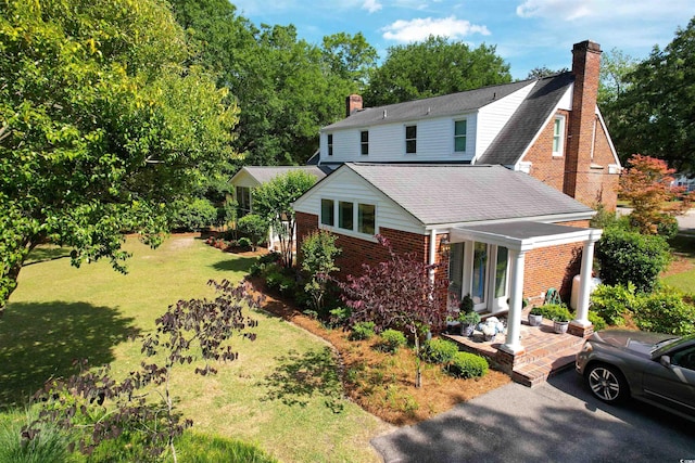 402 E Broad St, Hemingway, SC 29554 - view of front of property featuring brick siding, a chimney, a shingled roof, and a porch