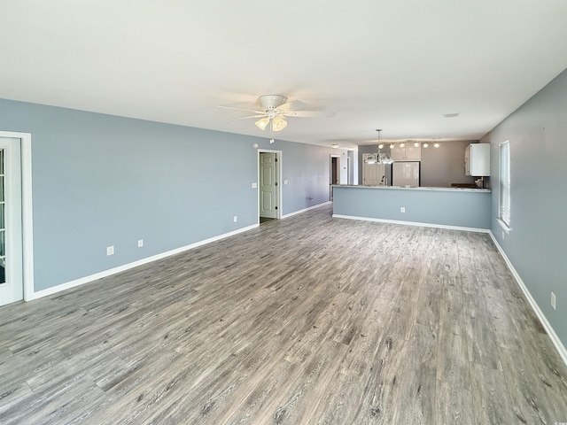 1041 Blue Stem Dr Unit 37A, Pawleys Island, SC 29585 - unfurnished living room with ceiling fan, wood finished floors, a chandelier, and baseboards