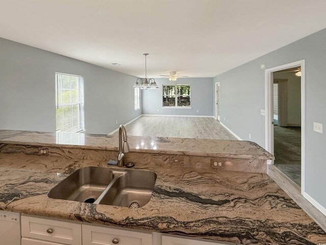 1041 Blue Stem Dr Unit 37A, Pawleys Island, SC 29585 - kitchen featuring a sink, light stone counters, white cabinets, light wood-style flooring, and open floor plan