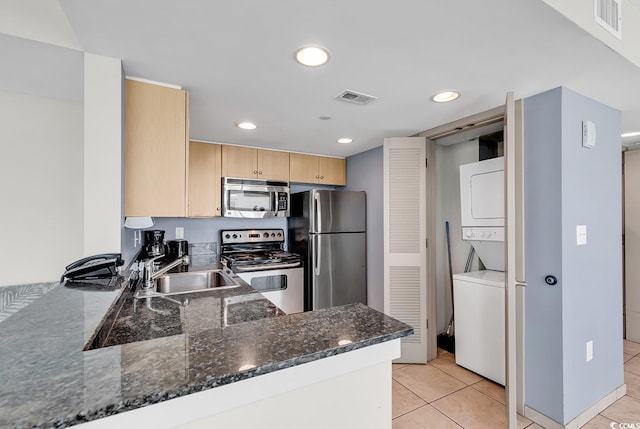 107 S Ocean Blvd Unit 1001, Myrtle Beach, SC 29577 - kitchen with a sink, visible vents, light brown cabinetry, stacked washing maching and dryer, and appliances with stainless steel finishes