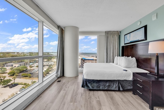 107 S Ocean Blvd Unit 1001, Myrtle Beach, SC 29577 - bedroom featuring a textured ceiling and light wood-style floors