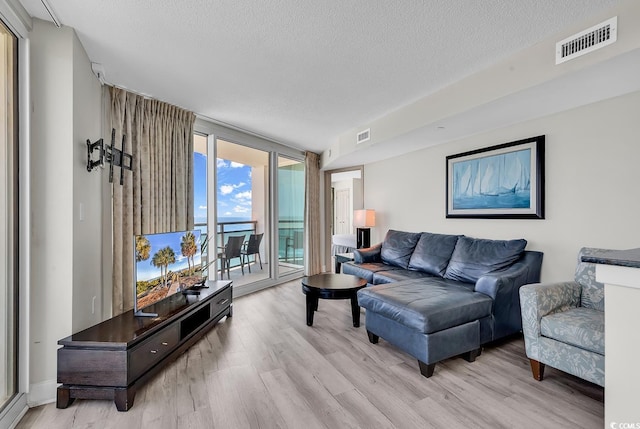 107 S Ocean Blvd Unit 1001, Myrtle Beach, SC 29577 - living area with light wood-style flooring, visible vents, a textured ceiling, and floor to ceiling windows