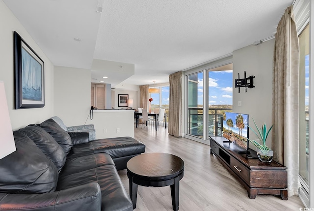 107 S Ocean Blvd Unit 1001, Myrtle Beach, SC 29577 - living area featuring light wood-style flooring, expansive windows, and a textured ceiling