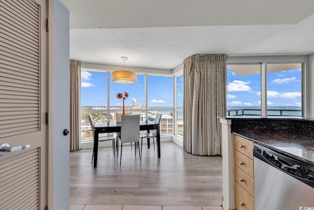 107 S Ocean Blvd Unit 1001, Myrtle Beach, SC 29577 - dining room with a textured ceiling, a water view, and light wood-type flooring