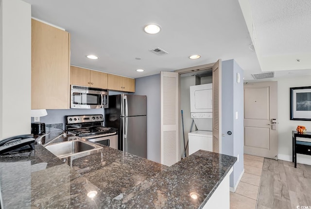 107 S Ocean Blvd Unit 1001, Myrtle Beach, SC 29577 - kitchen featuring a sink, stacked washer / dryer, visible vents, light brown cabinets, and appliances with stainless steel finishes