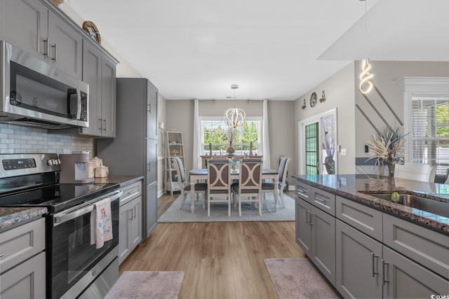 804 Twickenham Loop, Longs, SC 29568 - kitchen with hanging light fixtures, dark stone counters, light wood-style floors, gray cabinets, and appliances with stainless steel finishes
