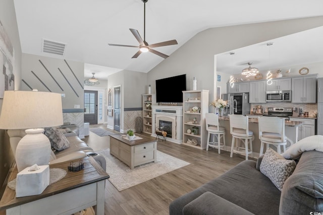 804 Twickenham Loop, Longs, SC 29568 - living room featuring a wainscoted wall, visible vents, ceiling fan, a glass covered fireplace, and light wood-style floors