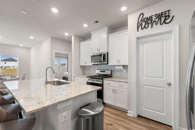 4609 Day Lily Run St, Myrtle Beach, SC 29579 - kitchen featuring stainless steel appliances, a sink, a breakfast bar area, light wood-style flooring, and an island with sink
