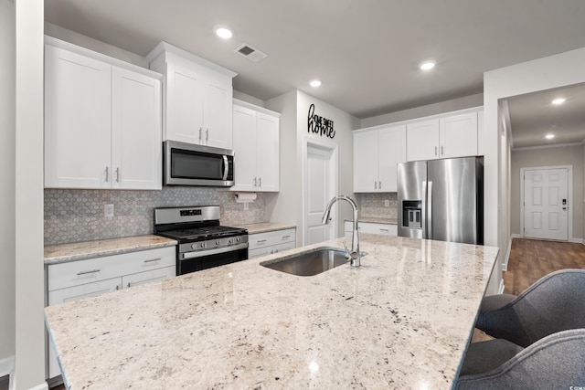4609 Day Lily Run St, Myrtle Beach, SC 29579 - kitchen featuring appliances with stainless steel finishes, a sink, an island with sink, white cabinets, and decorative backsplash
