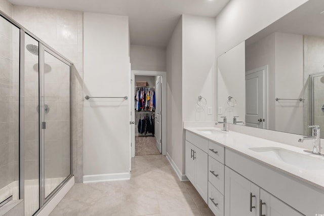 4609 Day Lily Run St, Myrtle Beach, SC 29579 - bathroom with a stall shower, a walk in closet, double vanity, baseboards, and tile patterned floors
