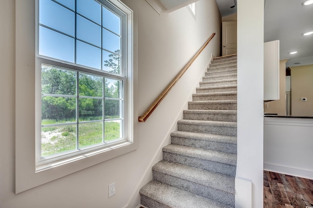 staircase with recessed lighting and wood finished floors