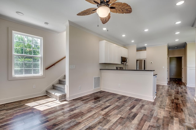 kitchen with ceiling fan, crown molding, dark wood-type flooring, dark countertops, and stainless steel appliances
