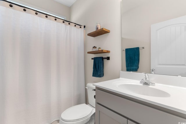 bathroom featuring curtained shower, vanity, and toilet