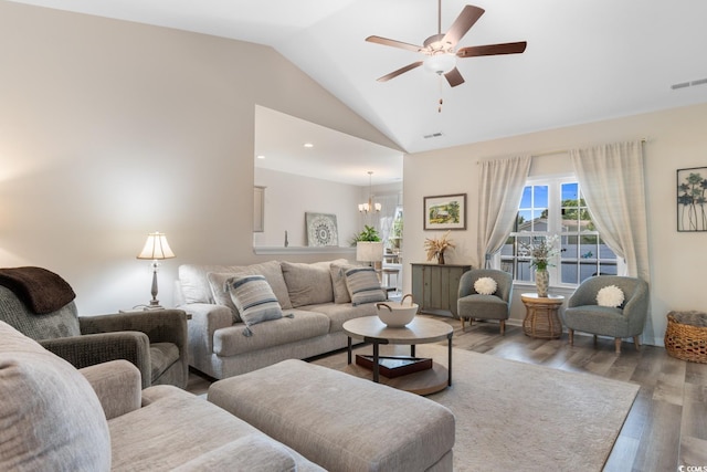 living room with vaulted ceiling, visible vents, wood finished floors, and ceiling fan with notable chandelier
