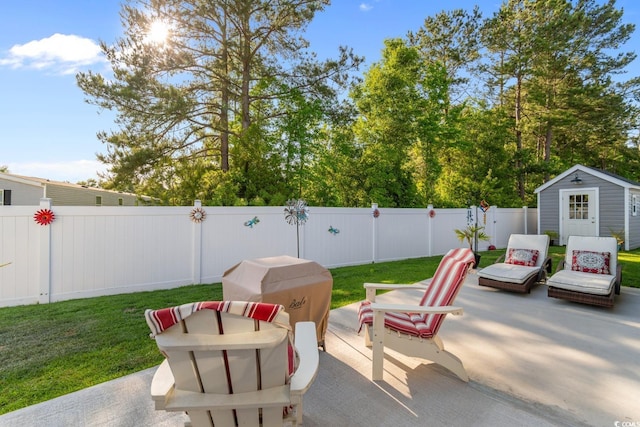 view of patio / terrace featuring an outbuilding, a fenced backyard, and a shed