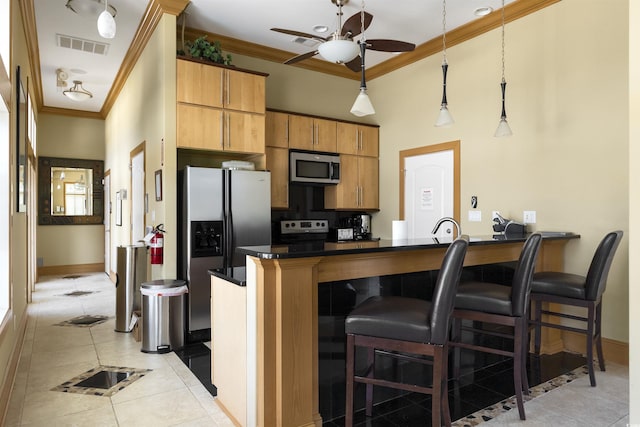 220 Waterfall Cir, Little River, SC 29566 - kitchen featuring light tile patterned floors, baseboards, a kitchen breakfast bar, crown molding, and stainless steel appliances