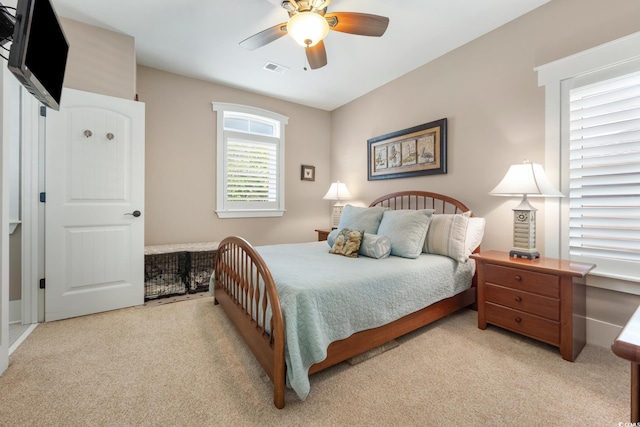 bedroom with visible vents, ceiling fan, and light colored carpet
