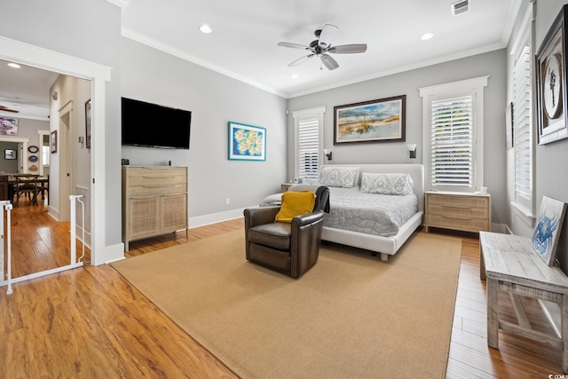 bedroom with crown molding, light wood-style flooring, visible vents, and recessed lighting