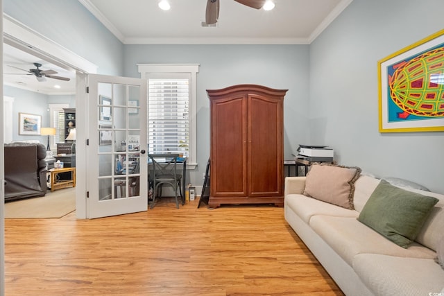 living room featuring ceiling fan, light wood-style flooring, crown molding, and french doors