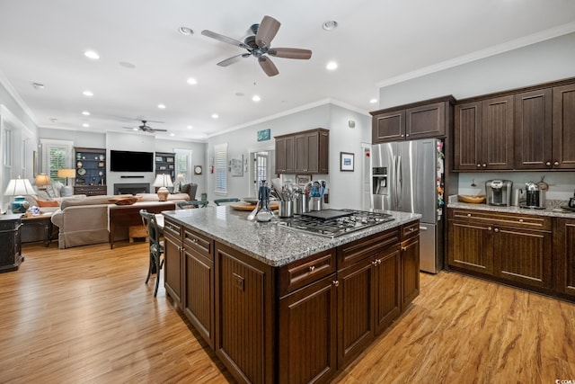 kitchen featuring a center island, light wood-style flooring, a ceiling fan, appliances with stainless steel finishes, and recessed lighting