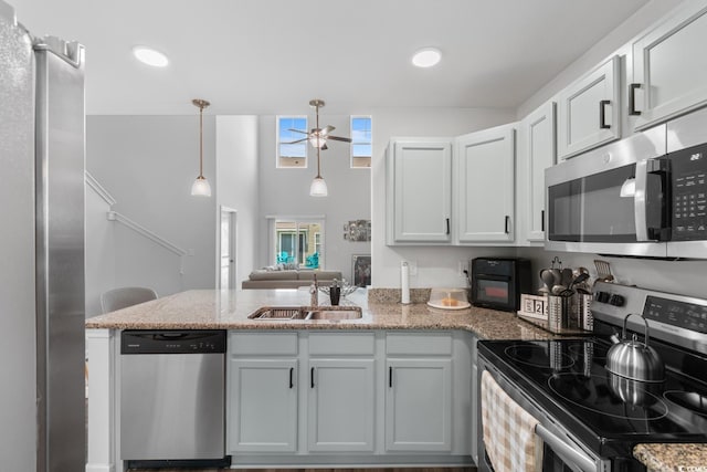 1123 Fairway Ln Unit 1123, Conway, SC 29526 - kitchen featuring light stone counters, ceiling fan, a sink, a peninsula, and appliances with stainless steel finishes
