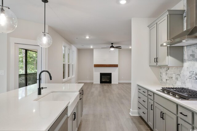 1061 Edenton Dr, Calabash, NC 28467 - kitchen with wall chimney range hood, a ceiling fan, recessed lighting, a sink, and stainless steel gas cooktop