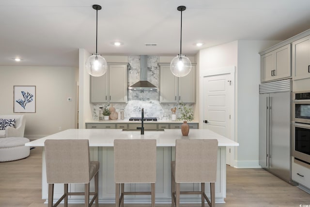 1061 Edenton Dr, Calabash, NC 28467 - kitchen featuring stainless steel appliances, gray cabinetry, a kitchen breakfast bar, and wall chimney exhaust hood