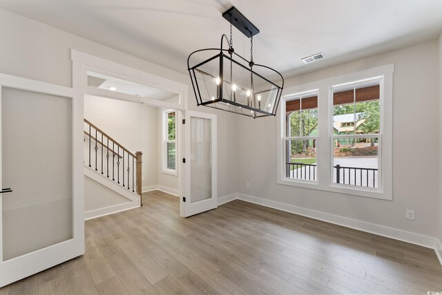 1061 Edenton Dr, Calabash, NC 28467 - unfurnished dining area featuring plenty of natural light, stairs, a chandelier, and baseboards
