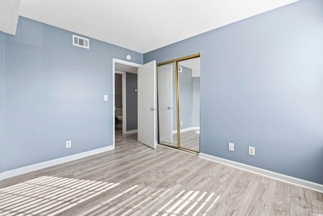 2258 Essex Dr Unit G, Surfside Beach, SC 29575 - unfurnished bedroom featuring wood finished floors, a closet, a textured ceiling, visible vents, and baseboards