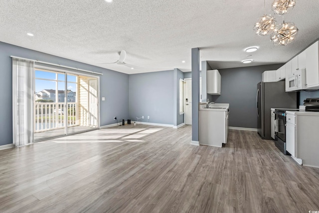 2258 Essex Dr Unit G, Surfside Beach, SC 29575 - unfurnished living room with wood finished floors, baseboards, and a sink