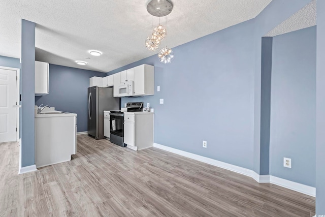 2258 Essex Dr Unit G, Surfside Beach, SC 29575 - kitchen with light wood-style floors, an inviting chandelier, baseboards, and appliances with stainless steel finishes