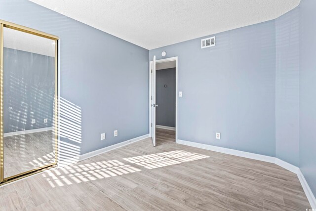 2258 Essex Dr Unit G, Surfside Beach, SC 29575 - empty room featuring a textured ceiling, baseboards, visible vents, and wood finished floors