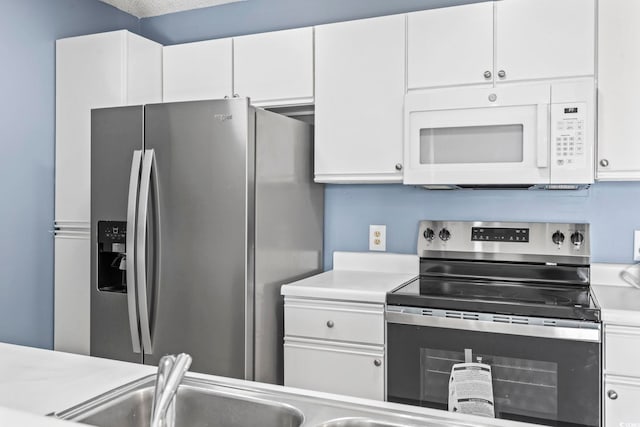 2258 Essex Dr Unit G, Surfside Beach, SC 29575 - kitchen featuring light countertops, white cabinets, and appliances with stainless steel finishes