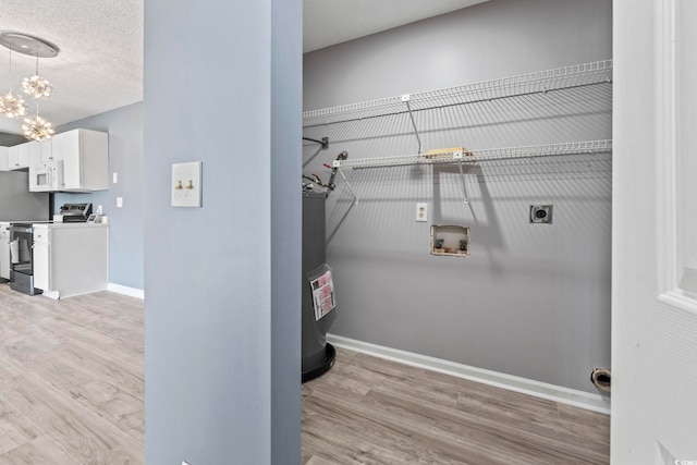 2258 Essex Dr Unit G, Surfside Beach, SC 29575 - clothes washing area featuring laundry area, light wood finished floors, an inviting chandelier, electric dryer hookup, and baseboards