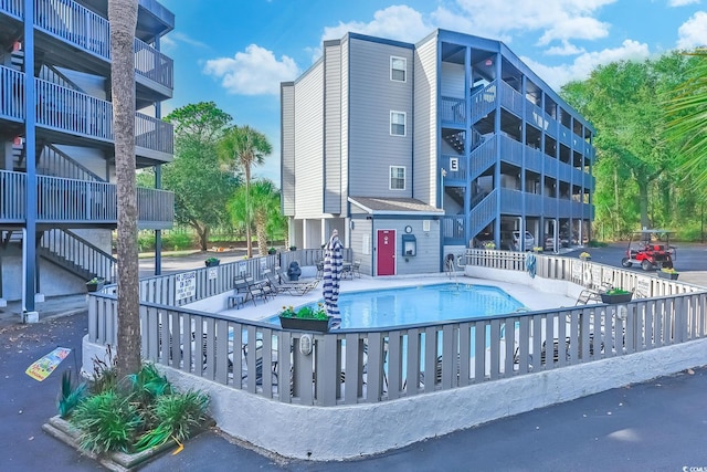 community pool featuring fence and a patio area